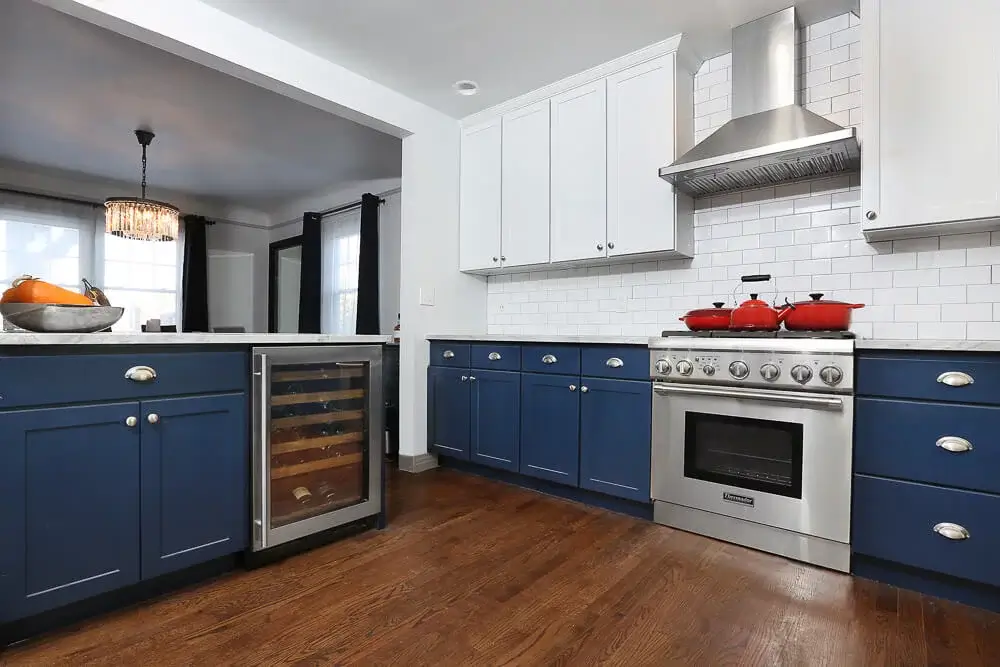 N-Hance blue and white kitchen with red pots and wine rack